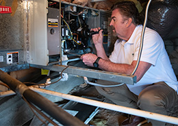 HouseMaster inspector reviewing air conditioning components inside of an attic.