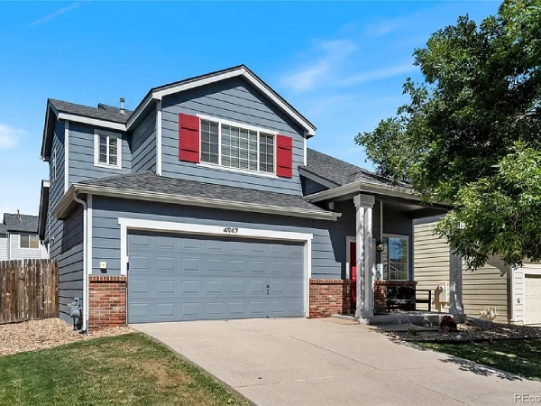 A home with a spacious garage and a driveway providing access to the front door.